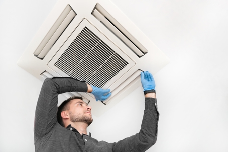 Young technician repairing air conditioner